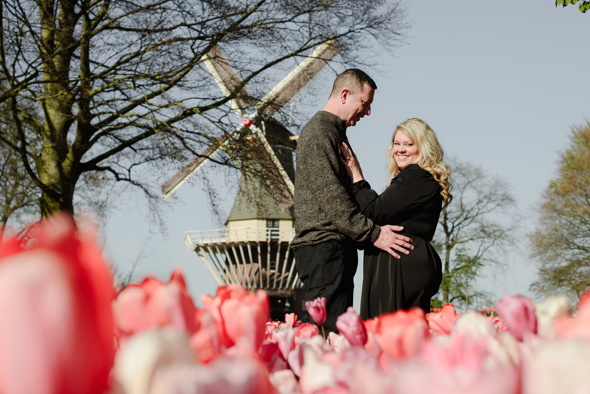 Couple portrait with a traditional Dutch windmill at Keukenhof Gardens