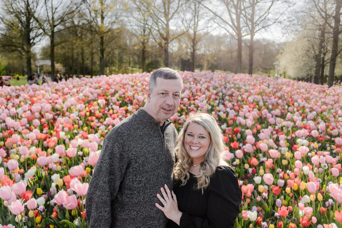 Couple portrait among blooming tulips during tulip season in the Netherlands