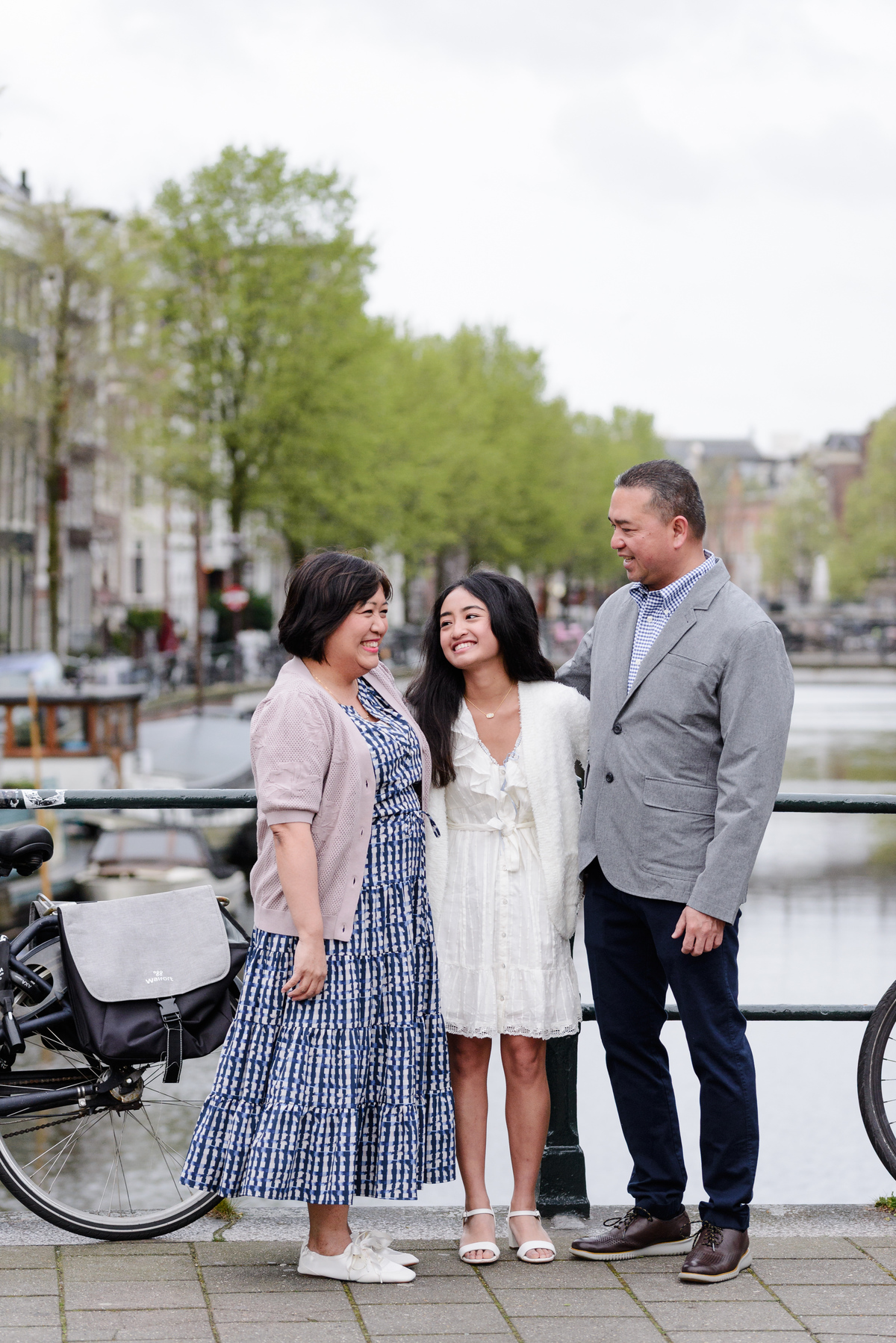 Family standing beside an Amsterdam canal during a photography session