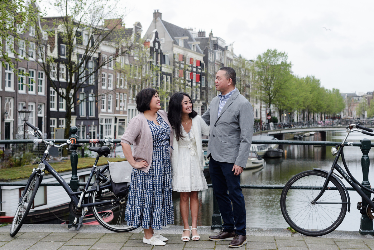 Family standing beside an Amsterdam canal during a photography session