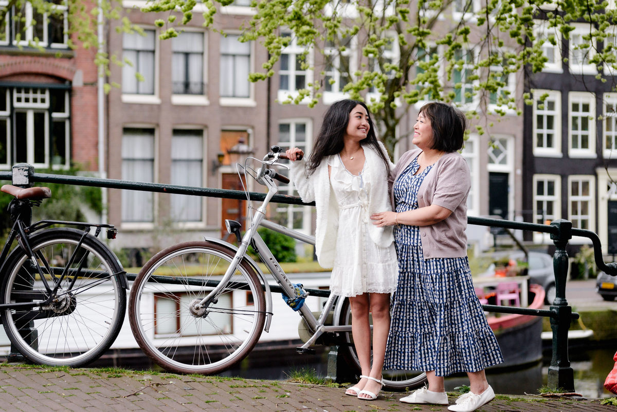 Mother and daughter sharing a moment beside an Amsterdam canal