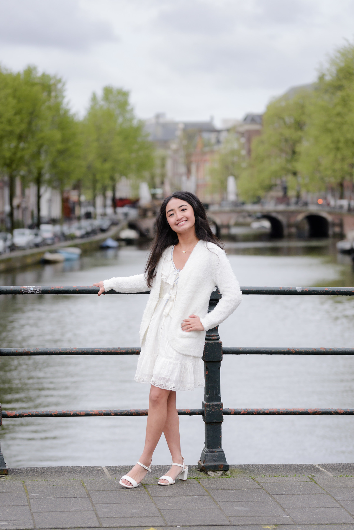 Young woman standing beside an Amsterdam canal during a family photography session