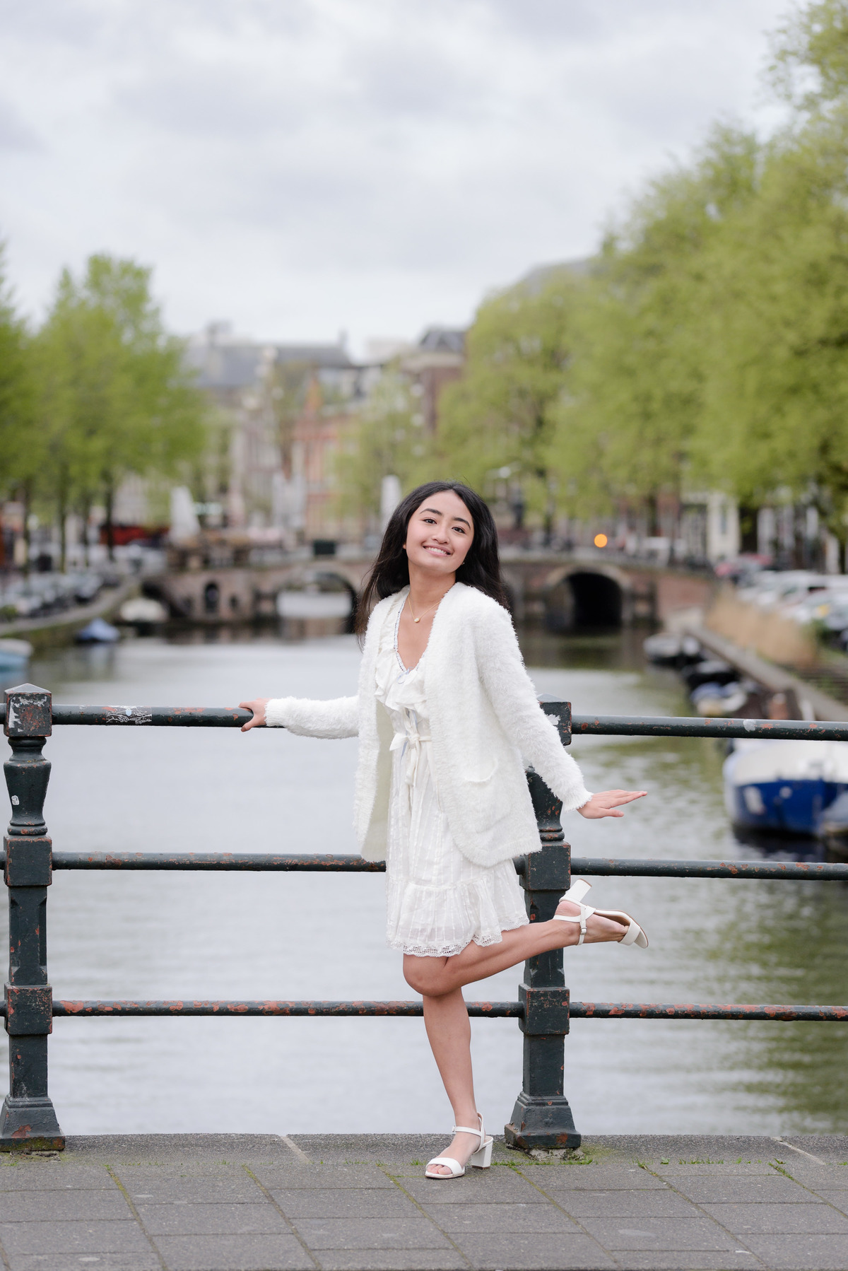Young traveler smiling beside Amsterdam's historic canals