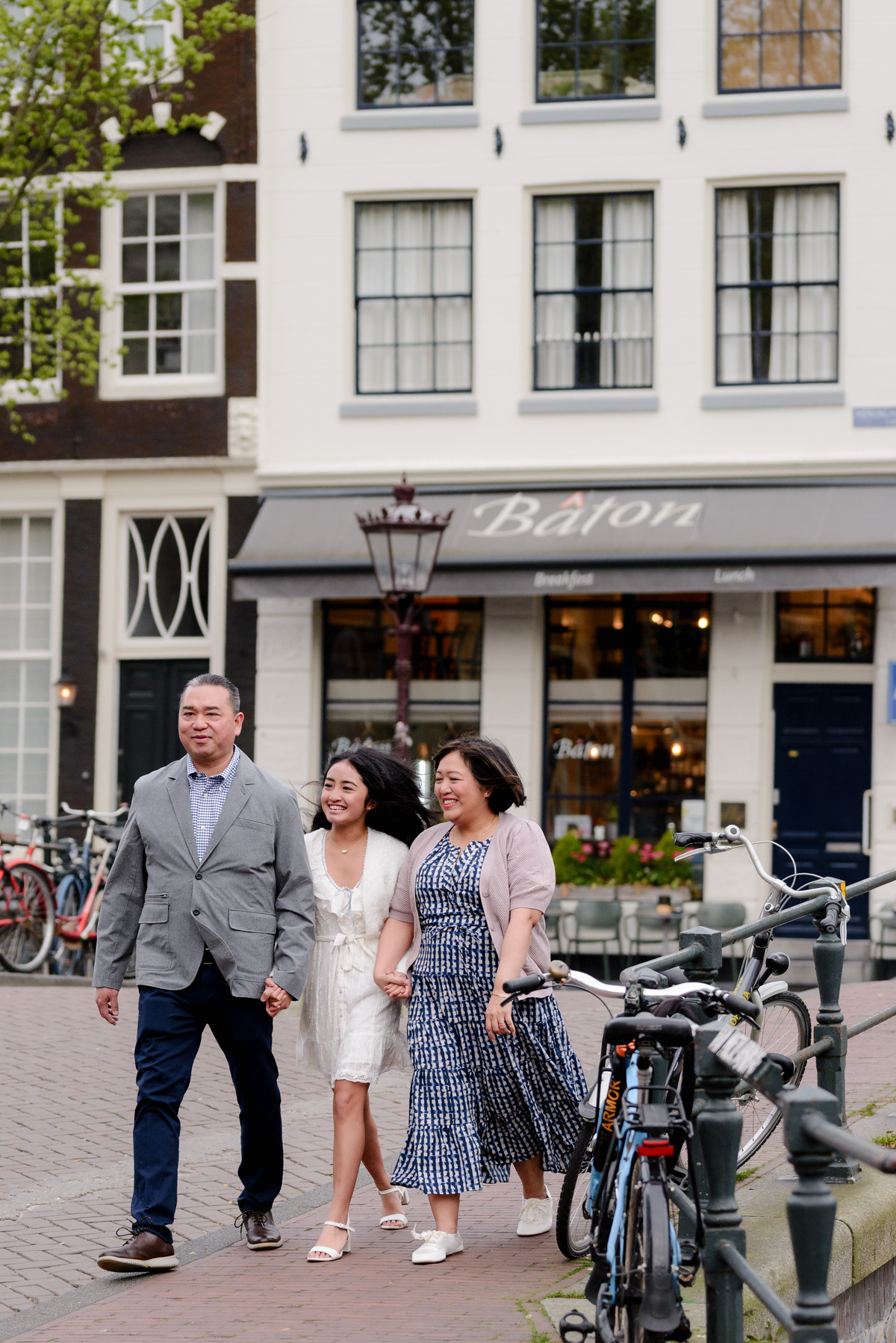 Family standing beside an Amsterdam canal during a photography session