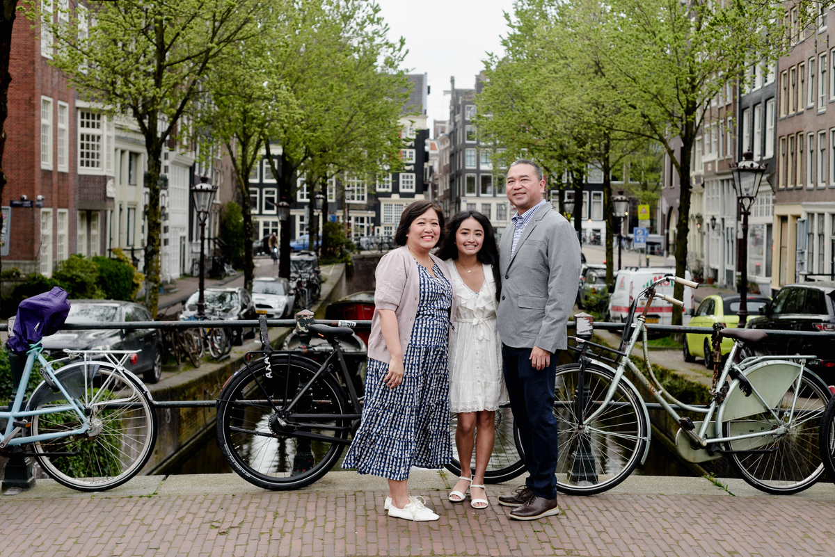 Family standing beside an Amsterdam canal during a photography session