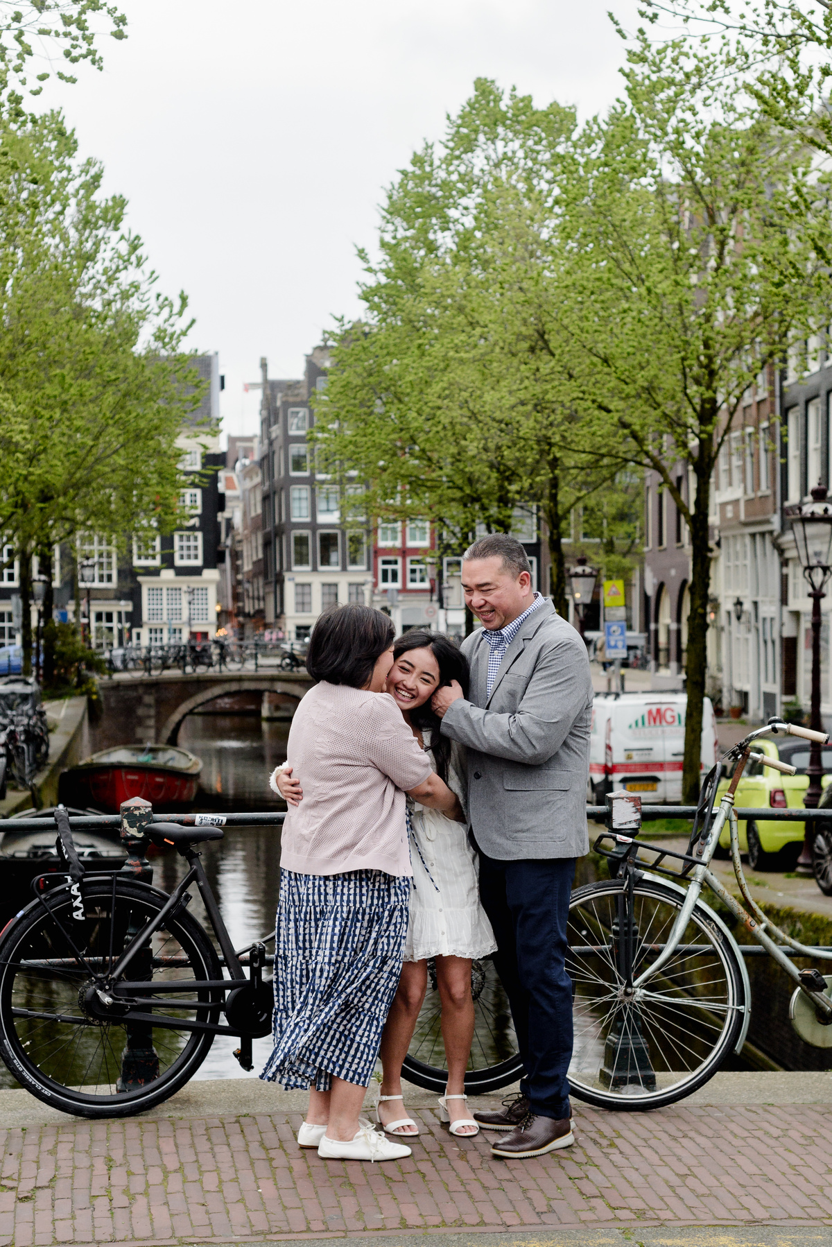 Family standing beside an Amsterdam canal during a photography session