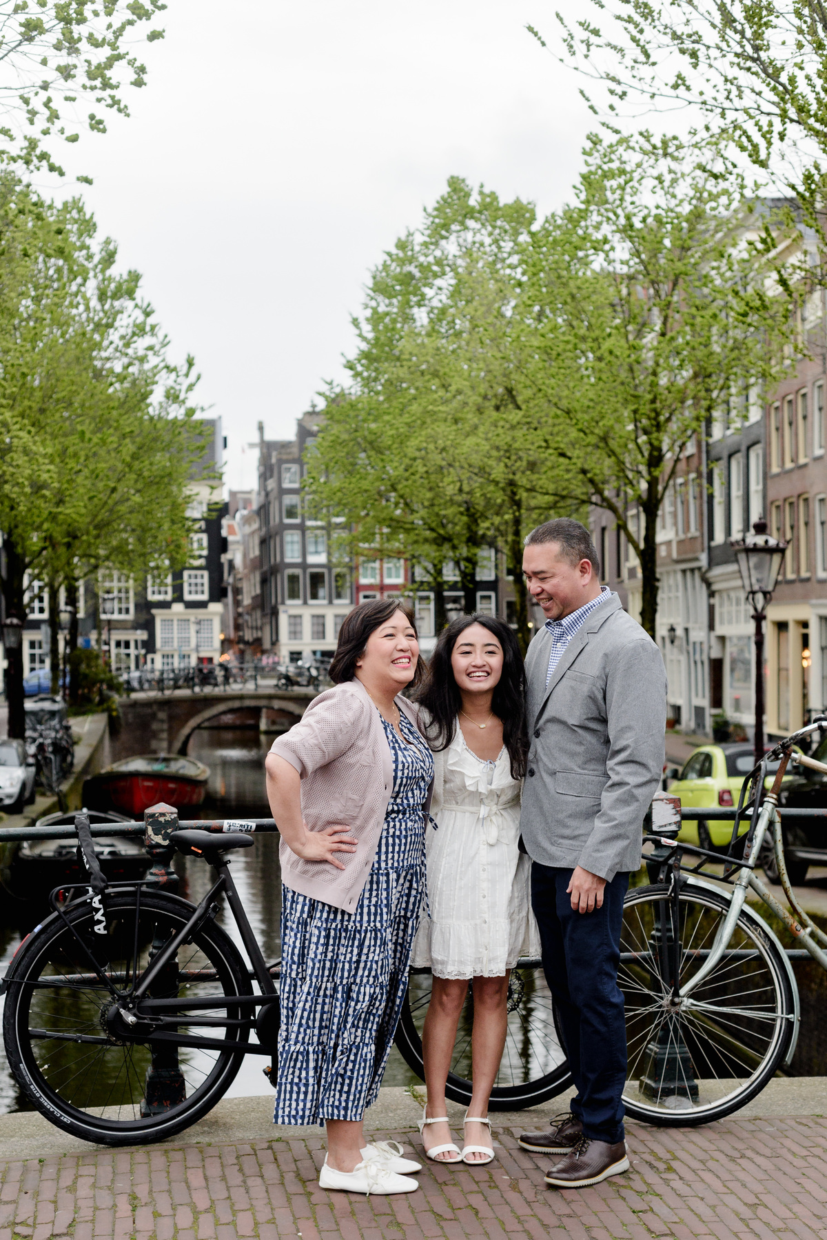 Family standing beside an Amsterdam canal during a photography session
