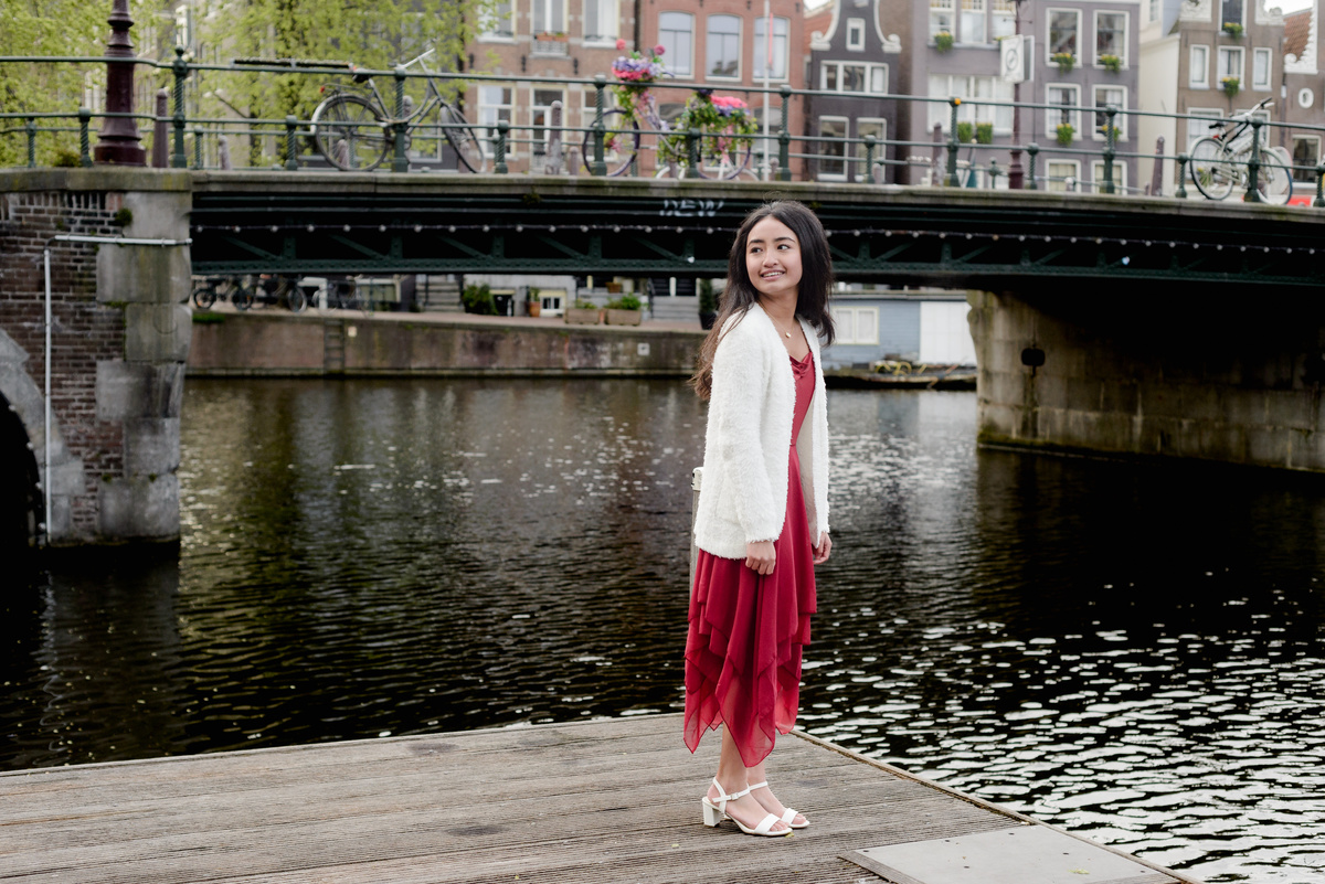 Portrait of a girl with canal houses in the background in Amsterdam