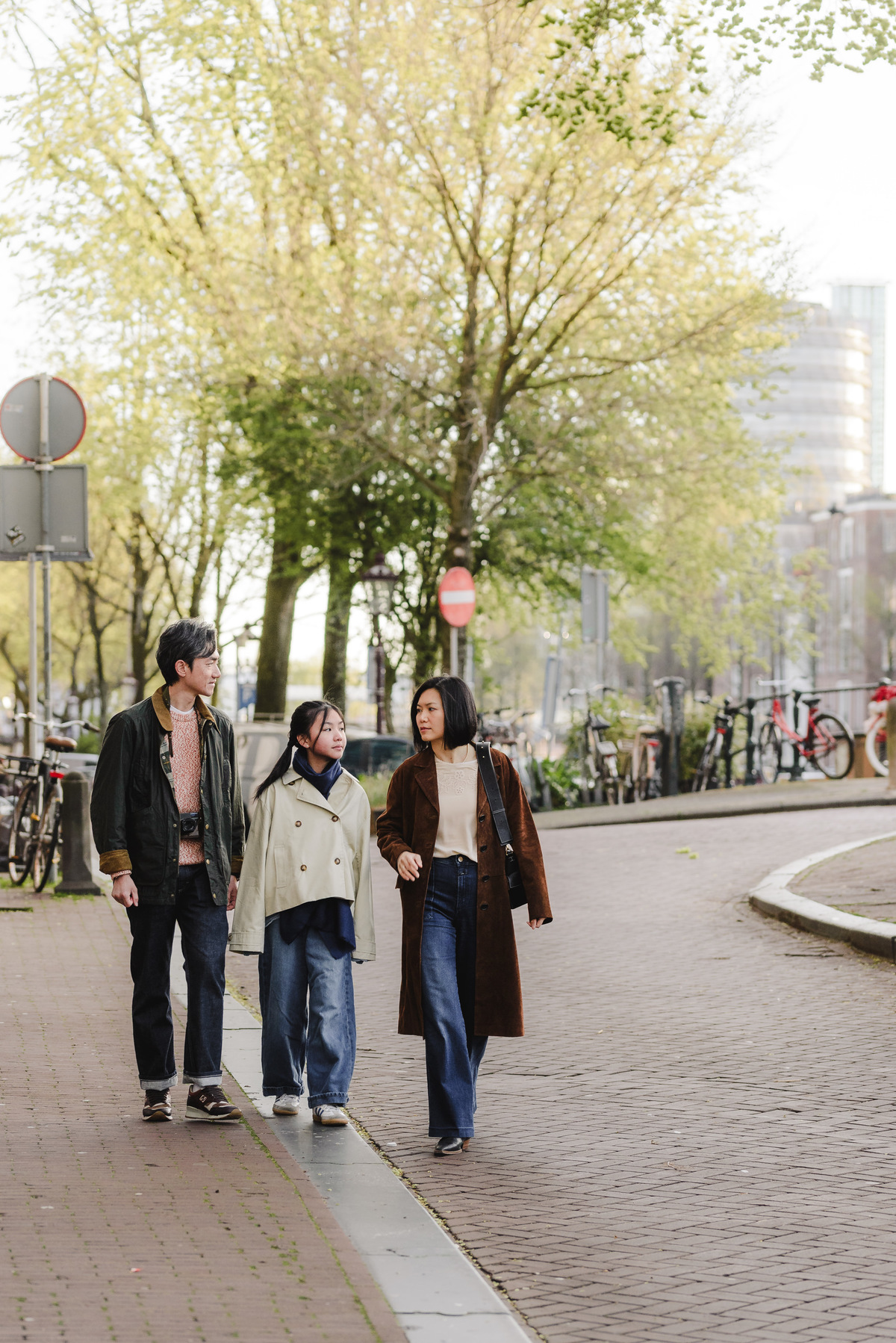 Parents and daughter walking through Amsterdam's Canal Belt