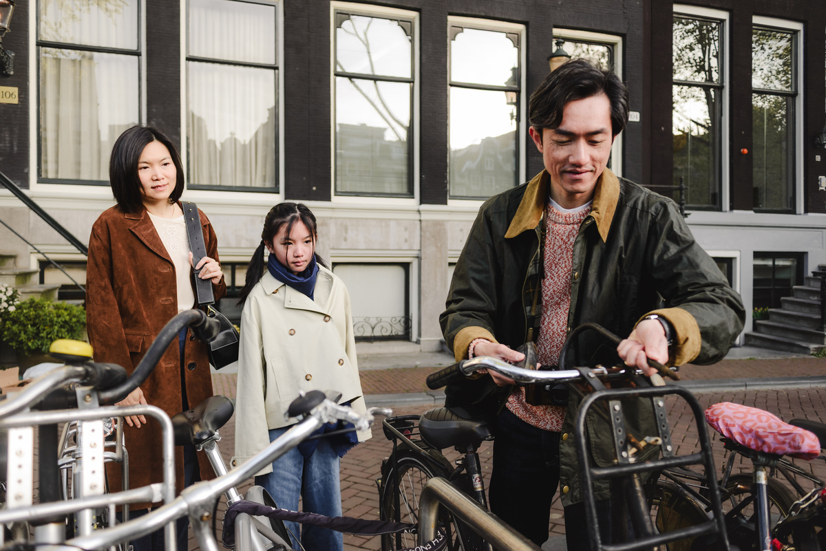 Family preparing to explore Amsterdam by bicycle along a canal