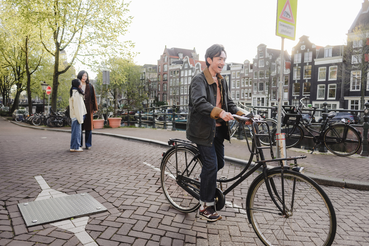 ather testing a bicycle during a family walk through Amsterdam