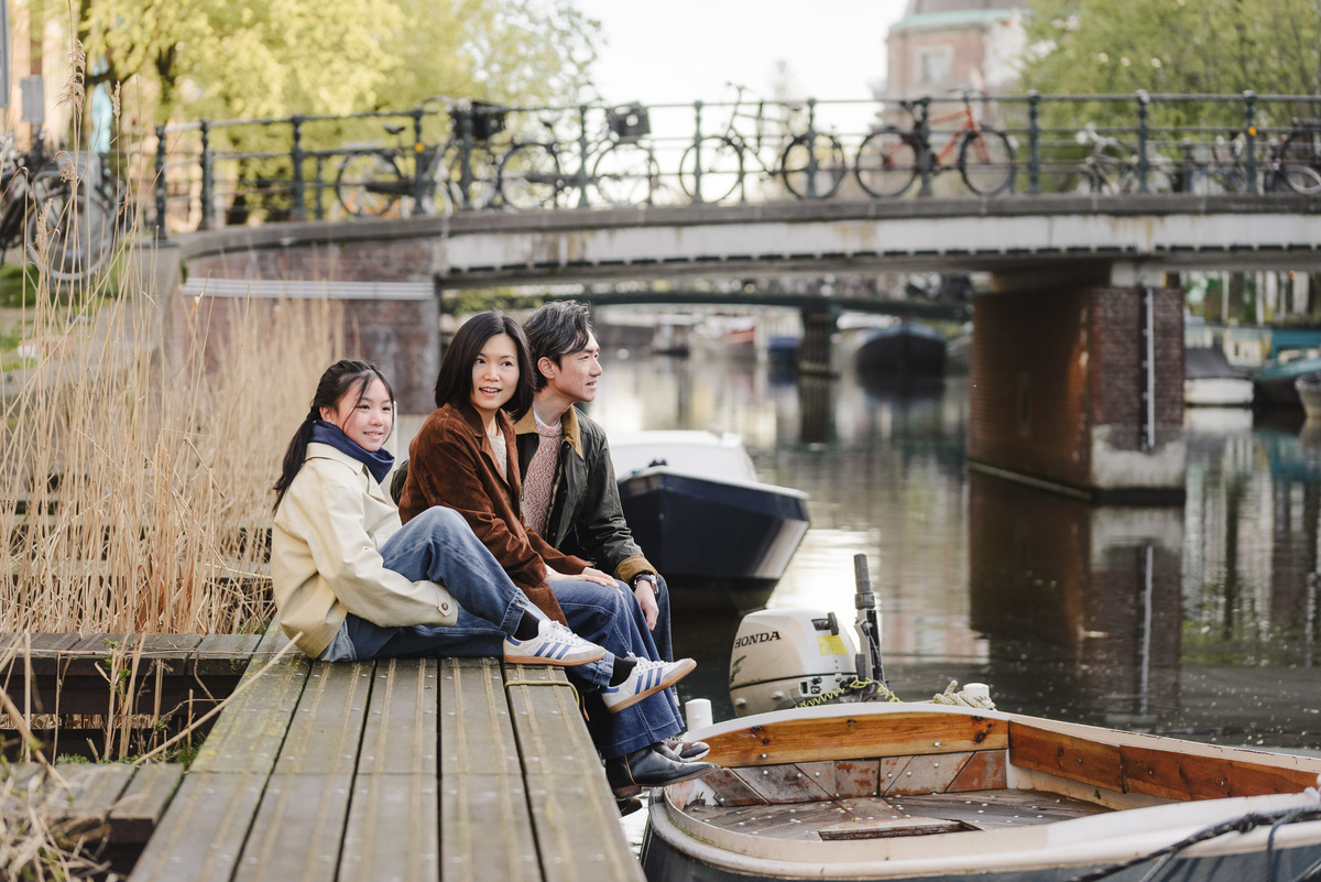 Family sitting beside a canal during a relaxed morning in Amsterdam
