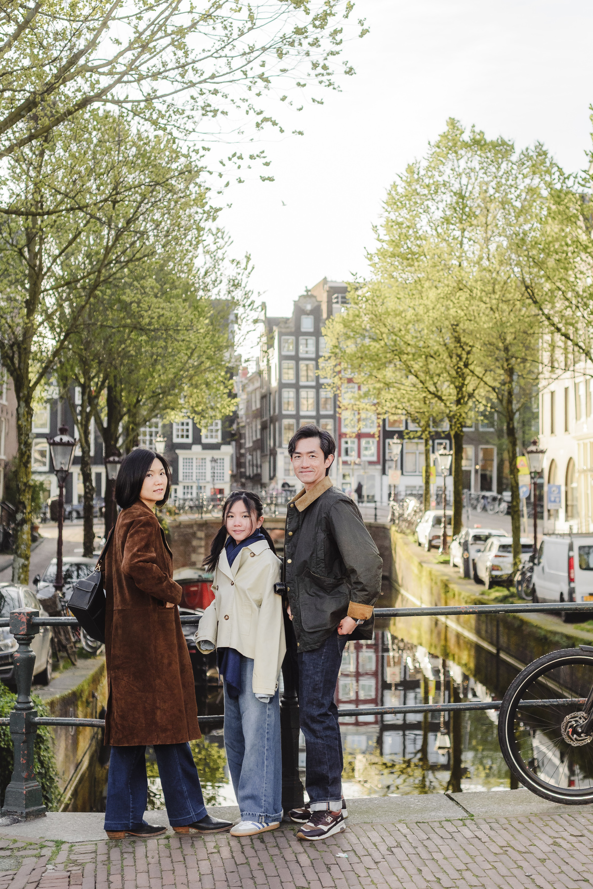 Family standing together along a canal in Amsterdam