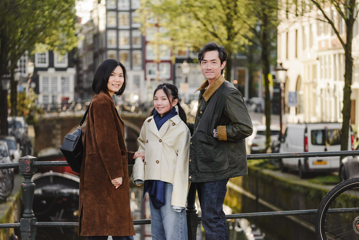 Family standing together along a canal in Amsterdam