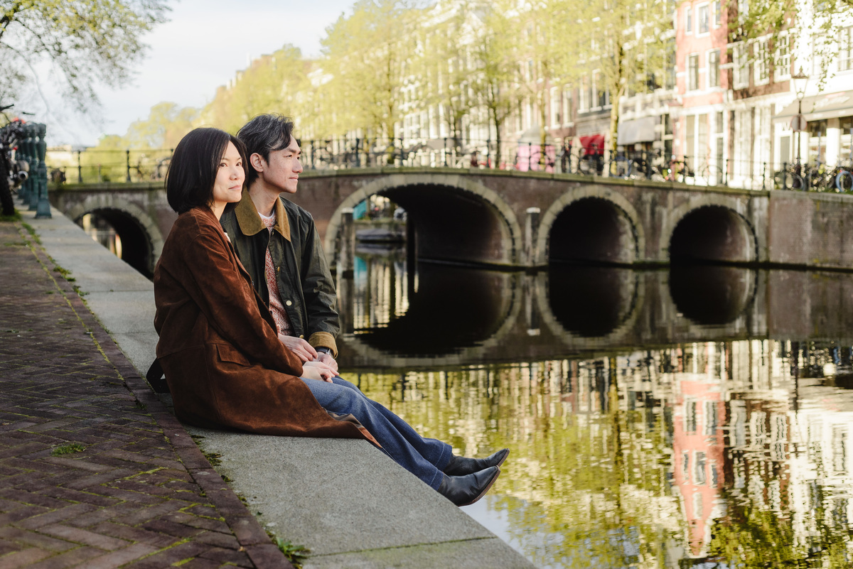 Parents relaxing beside a canal in Amsterdam