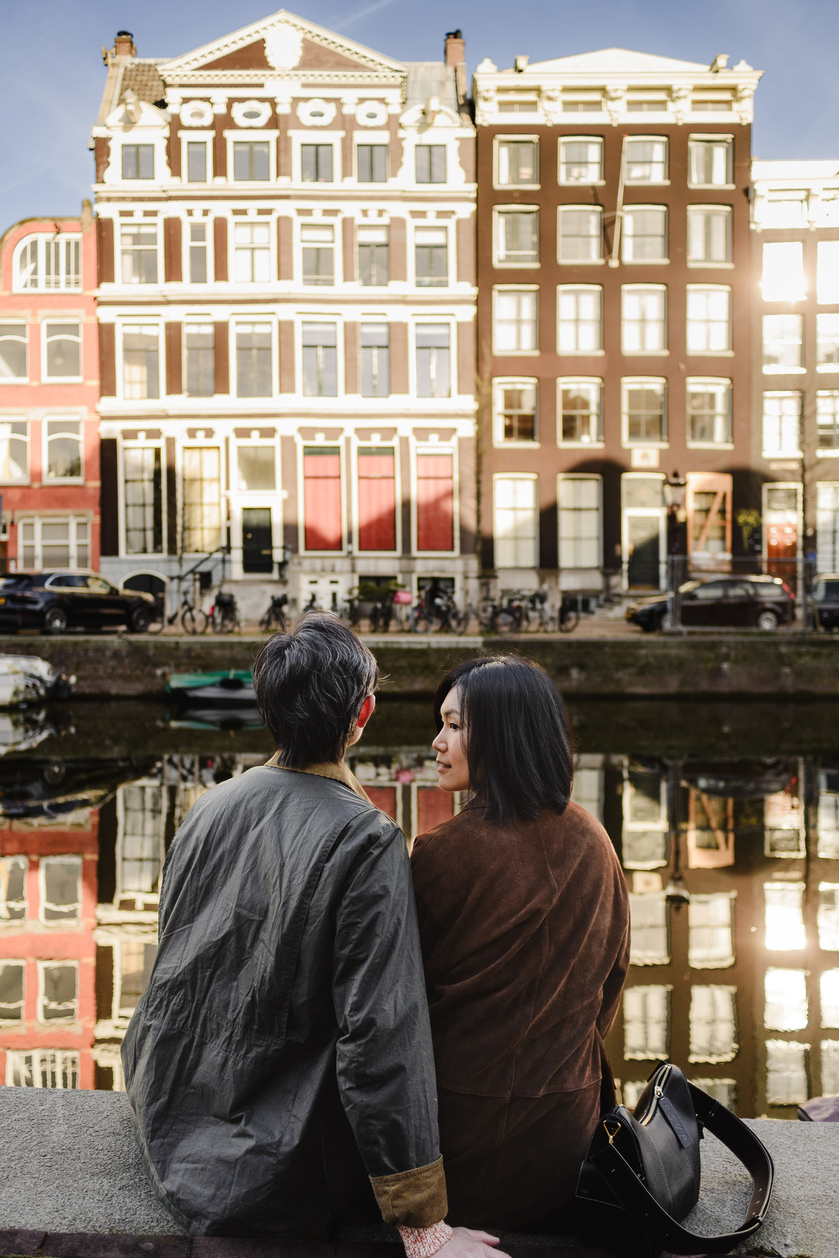Parents relaxing beside a canal in Amsterdam