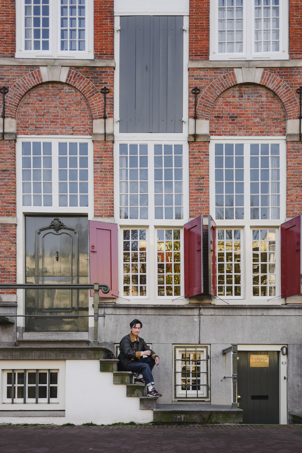 Father sitting on a canal house staircase in Amsterdam