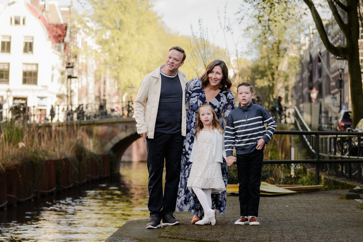 Parents and children standing together beside an Amsterdam canal