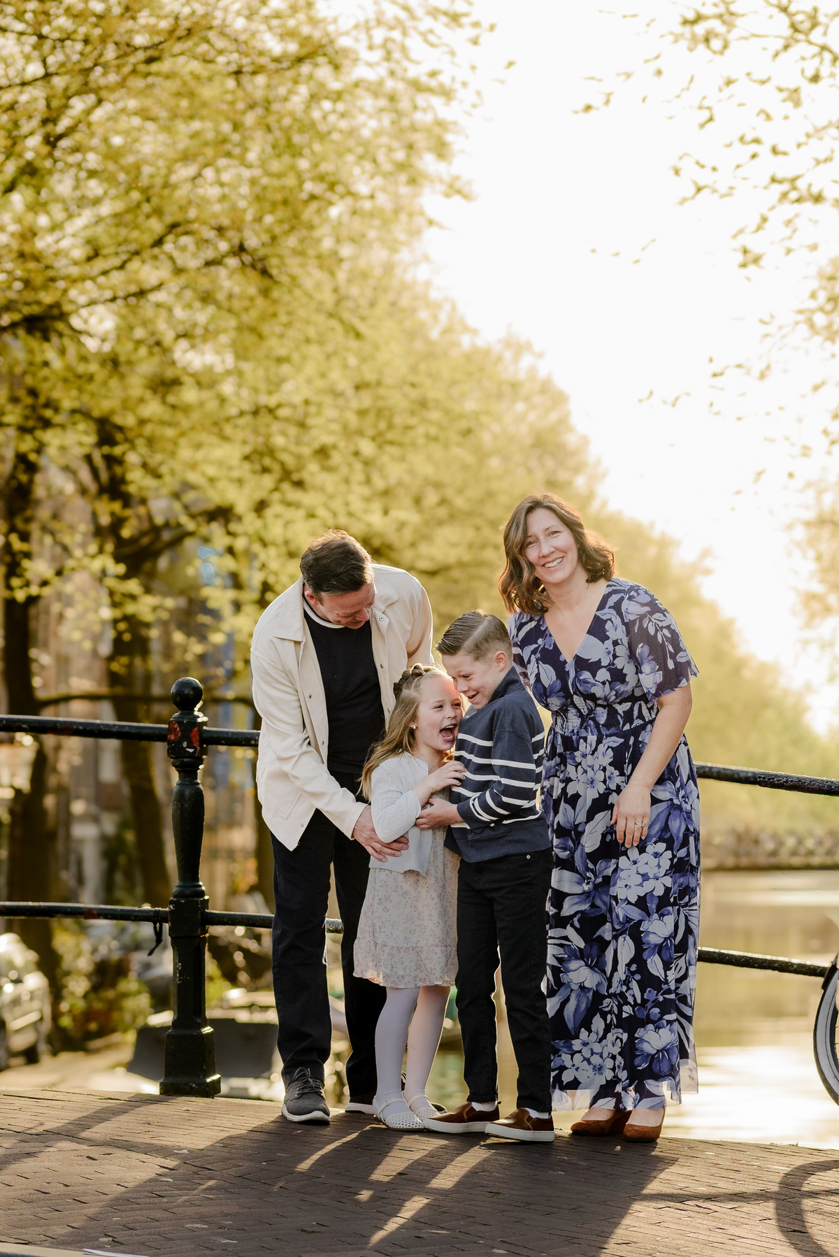 Parents and children standing together beside an Amsterdam canal
