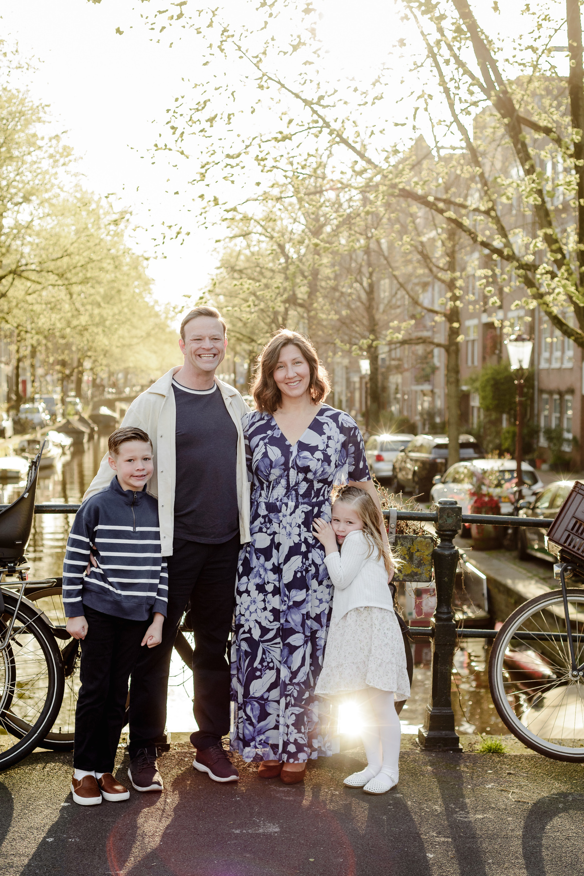 Family portrait beside a canal during golden hour in Amsterdam