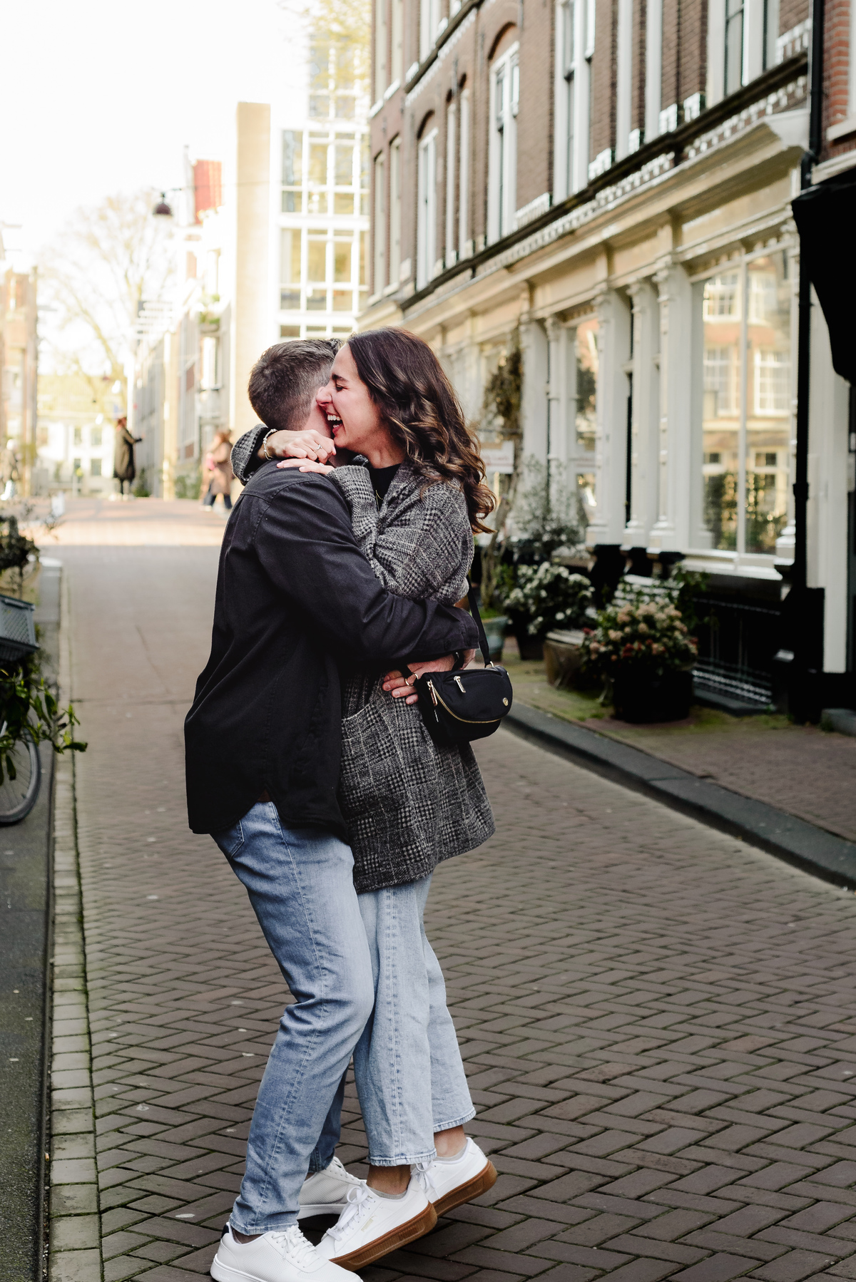 Newly engaged couple celebrating together on a quiet street in Jordaan
