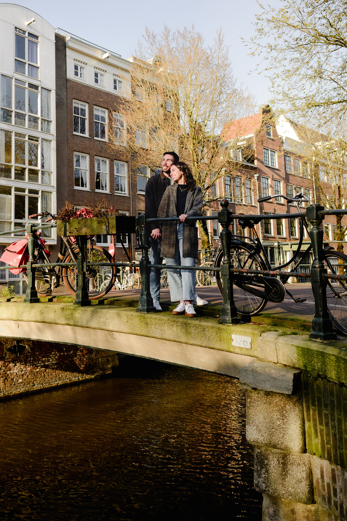 Engaged couple standing on a canal bridge in Amsterdam after the proposal