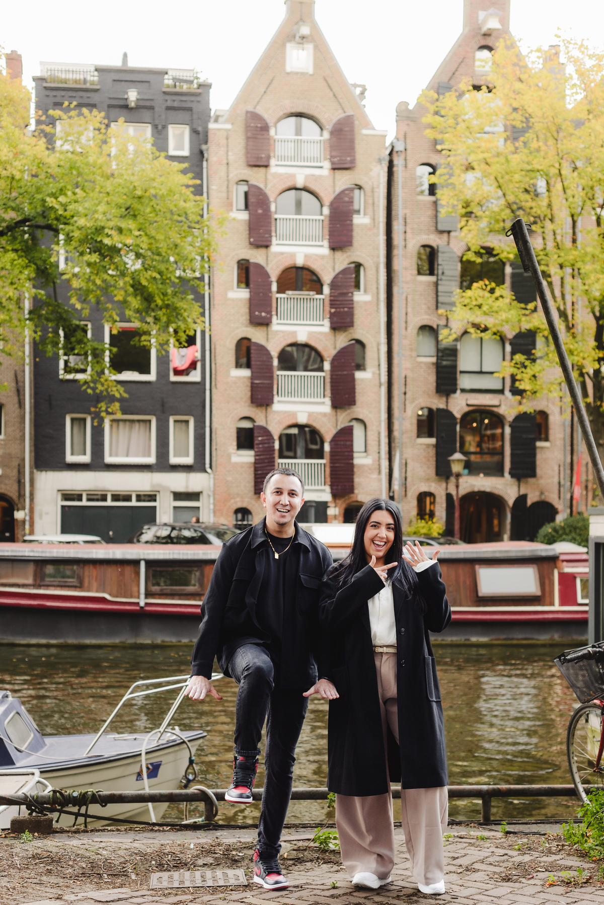Recently engaged couple embracing and smiling after a surprise proposal during a photography session in Amsterdam.