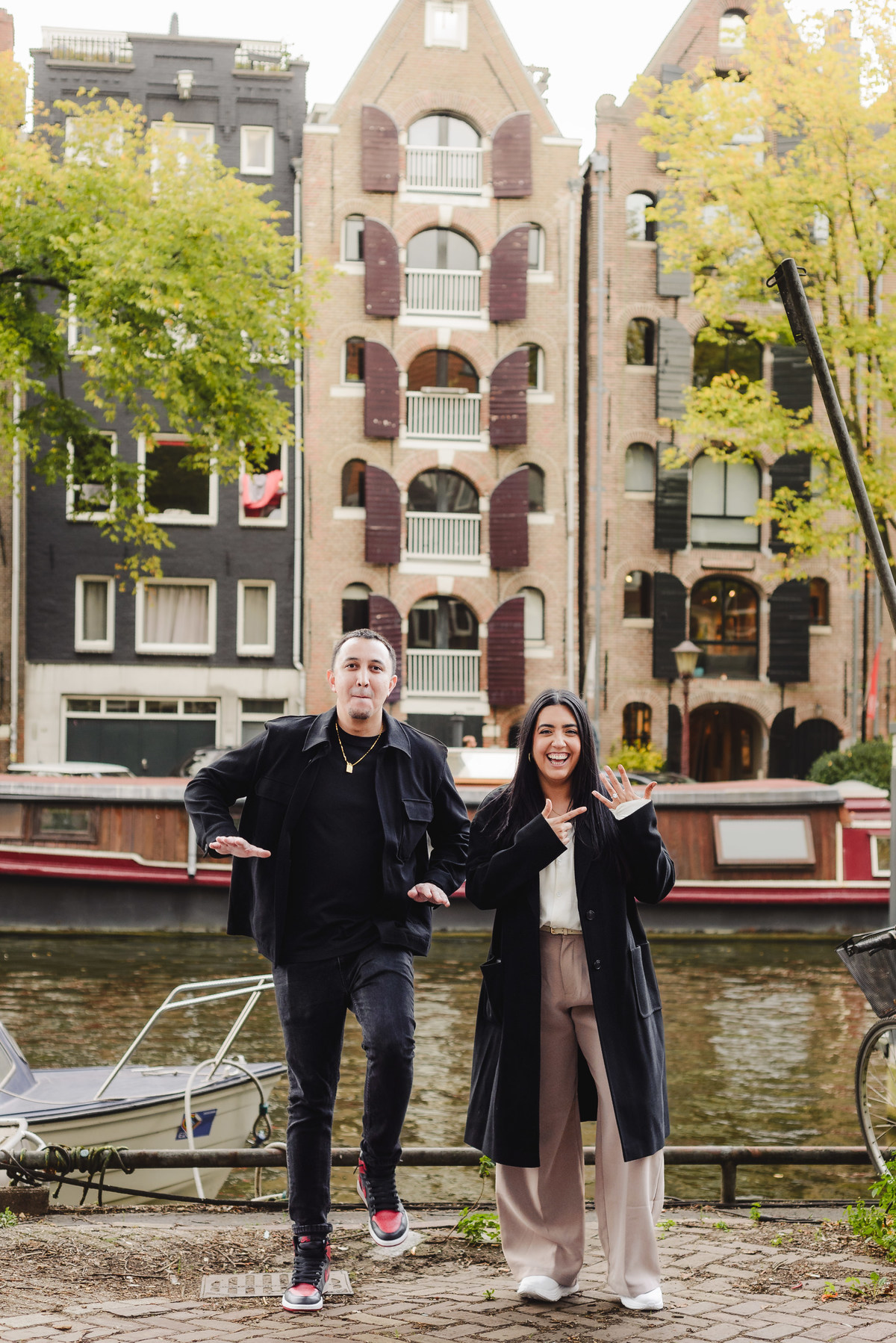 Recently engaged couple embracing and smiling after a surprise proposal during a photography session in Amsterdam.