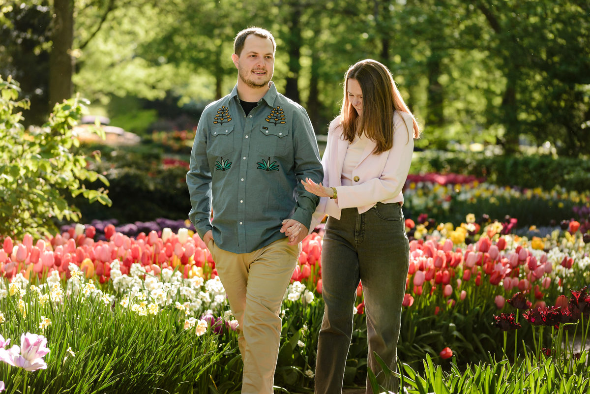 Couple strolling through Keukenhof Gardens framed by colorful tulips.