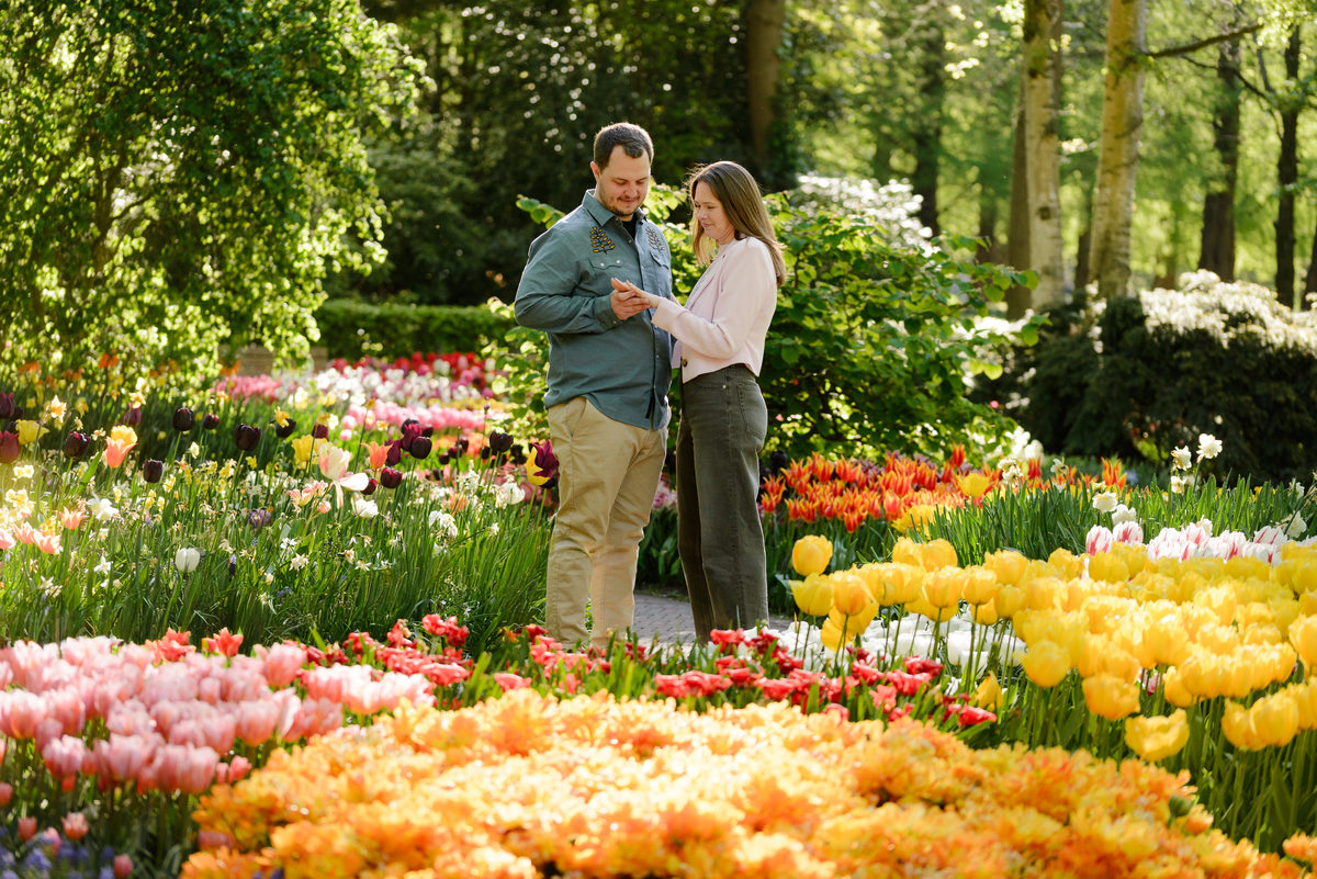 Engagement portraits surrounded by vibrant tulip displays during spring.