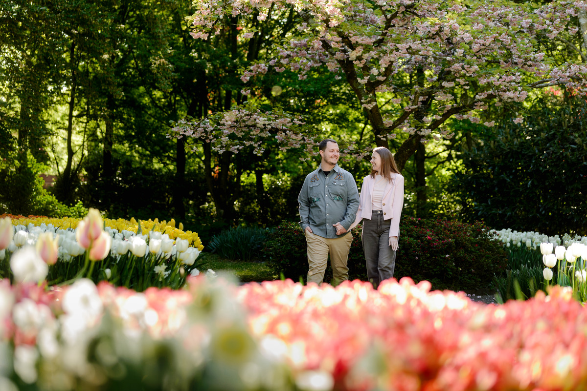 Couple exploring Keukenhof Gardens surrounded by colorful flower displays.