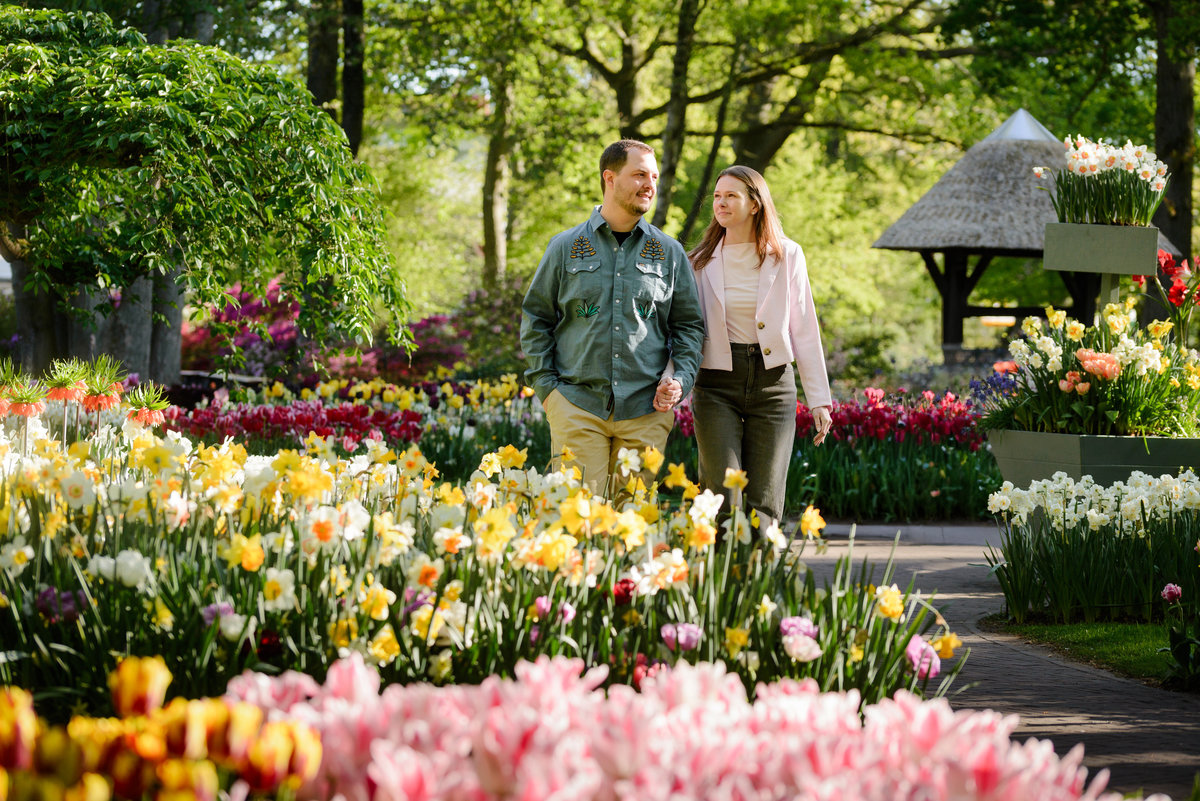 Couple exploring Keukenhof Gardens surrounded by colorful flower displays.