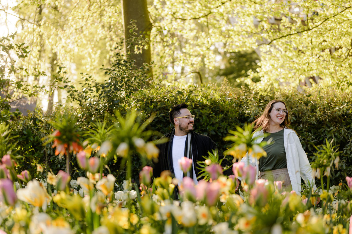 Couple enjoying a quiet moment among blooming tulips during an engagement photography session.