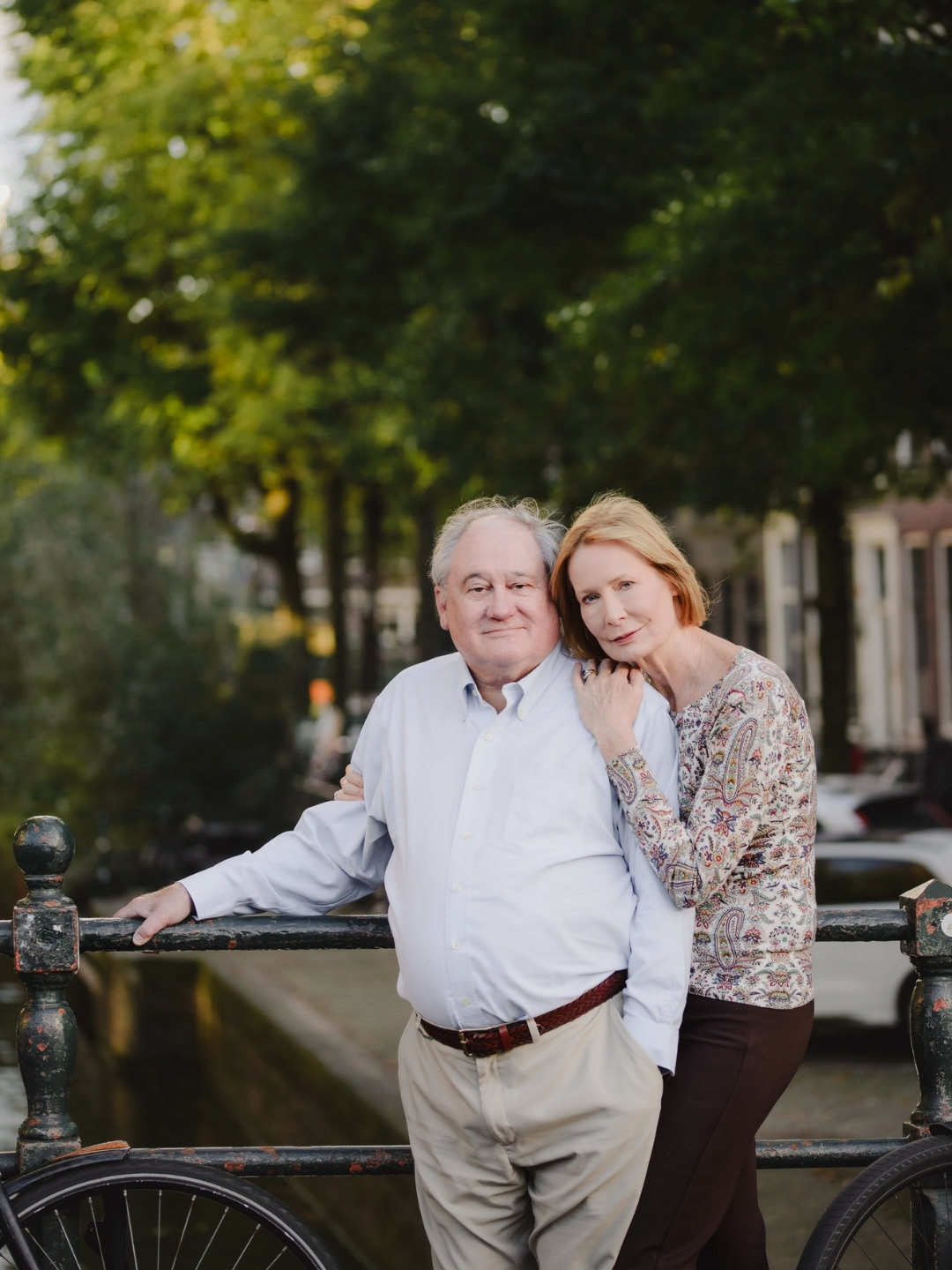 Couple standing together beside a canal bridge during a relaxed photography session in Amsterdam.