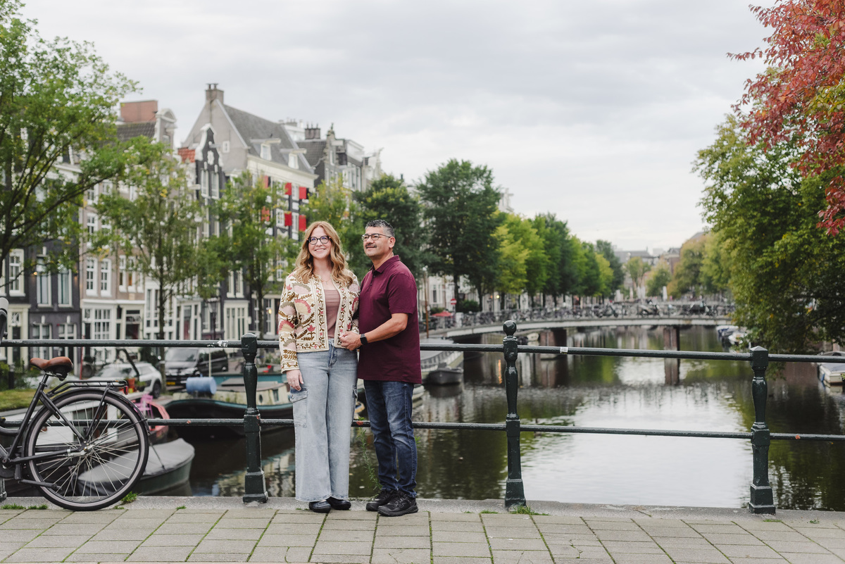 Couple in front of the single canal in Amsterdam during their vacation photo session