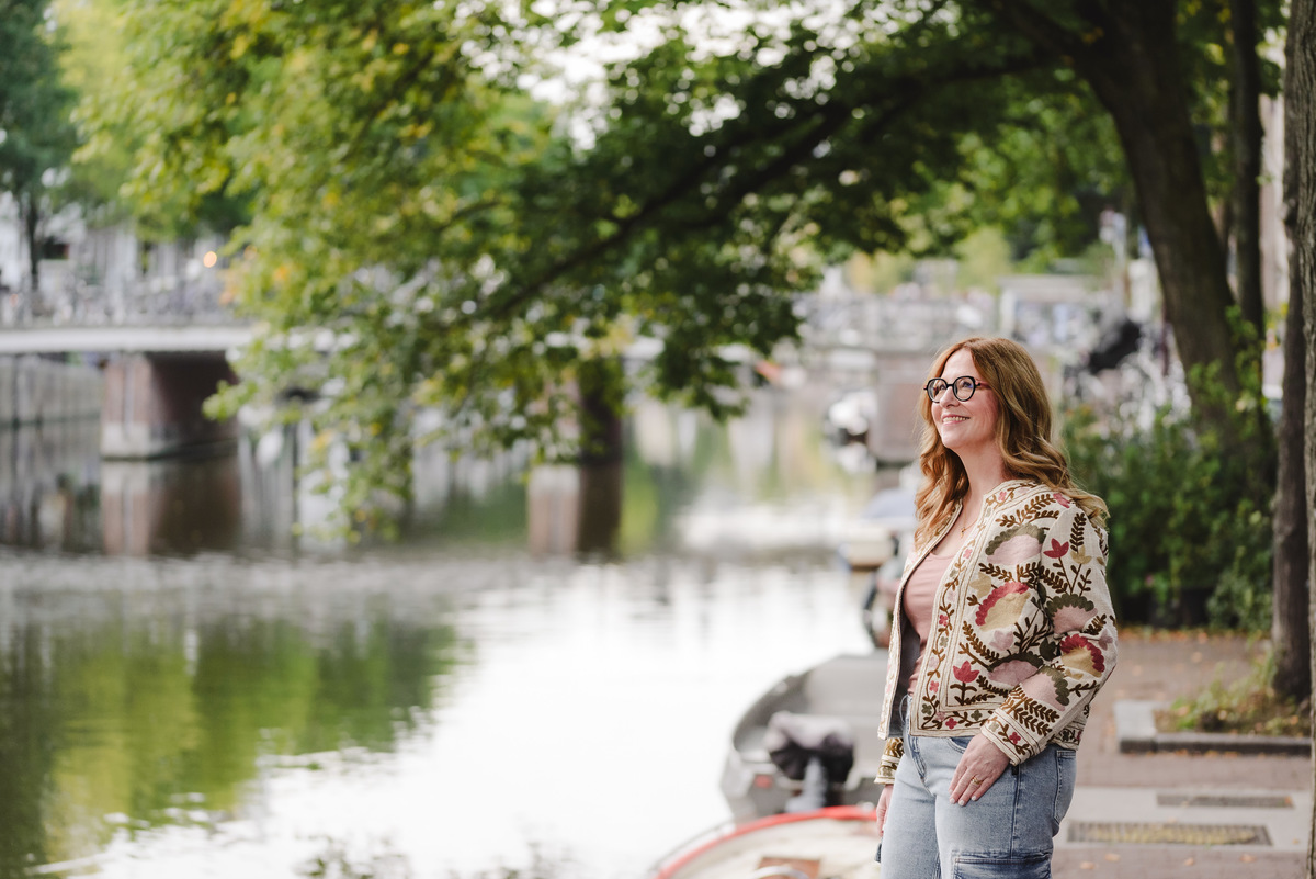 Female business owner next to a canal in Amsterdam with beautiful bridges in the background. This was part of a business portrait photo session in Amsterdam. 
