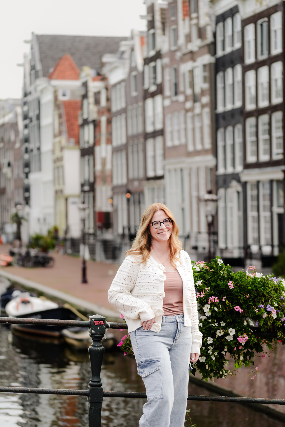 Business portrait of an owner of a luxury travel agency in front of a historical street filled with monumental houses in Amsterdam 