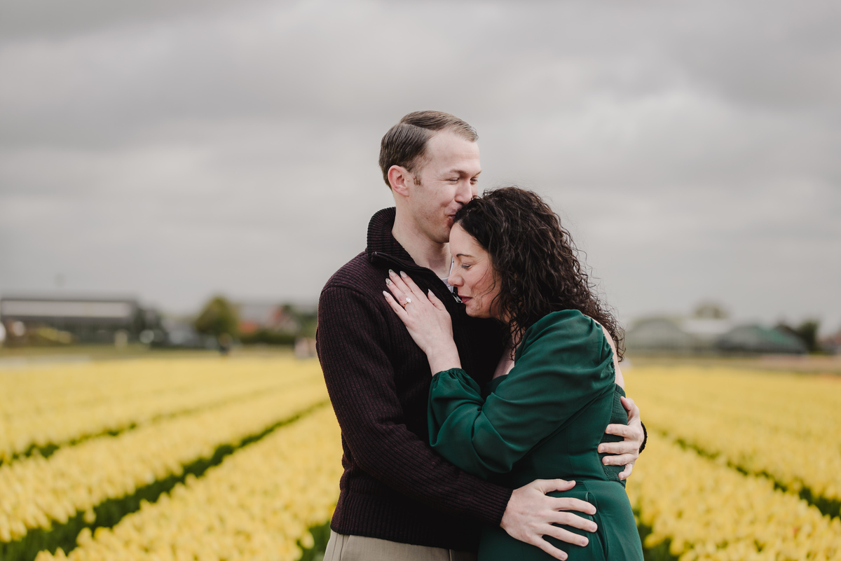 Couple embracing in a private tulip field during spring.