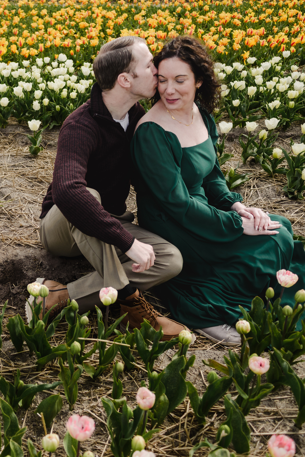 Couple embracing among colourful tulips in the Netherlands.