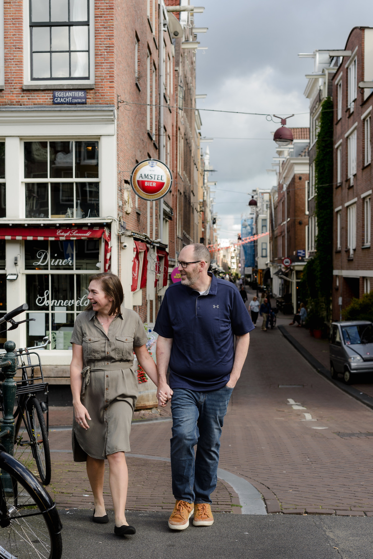 Couple walking hand in hand through the historic streets of Amsterdam