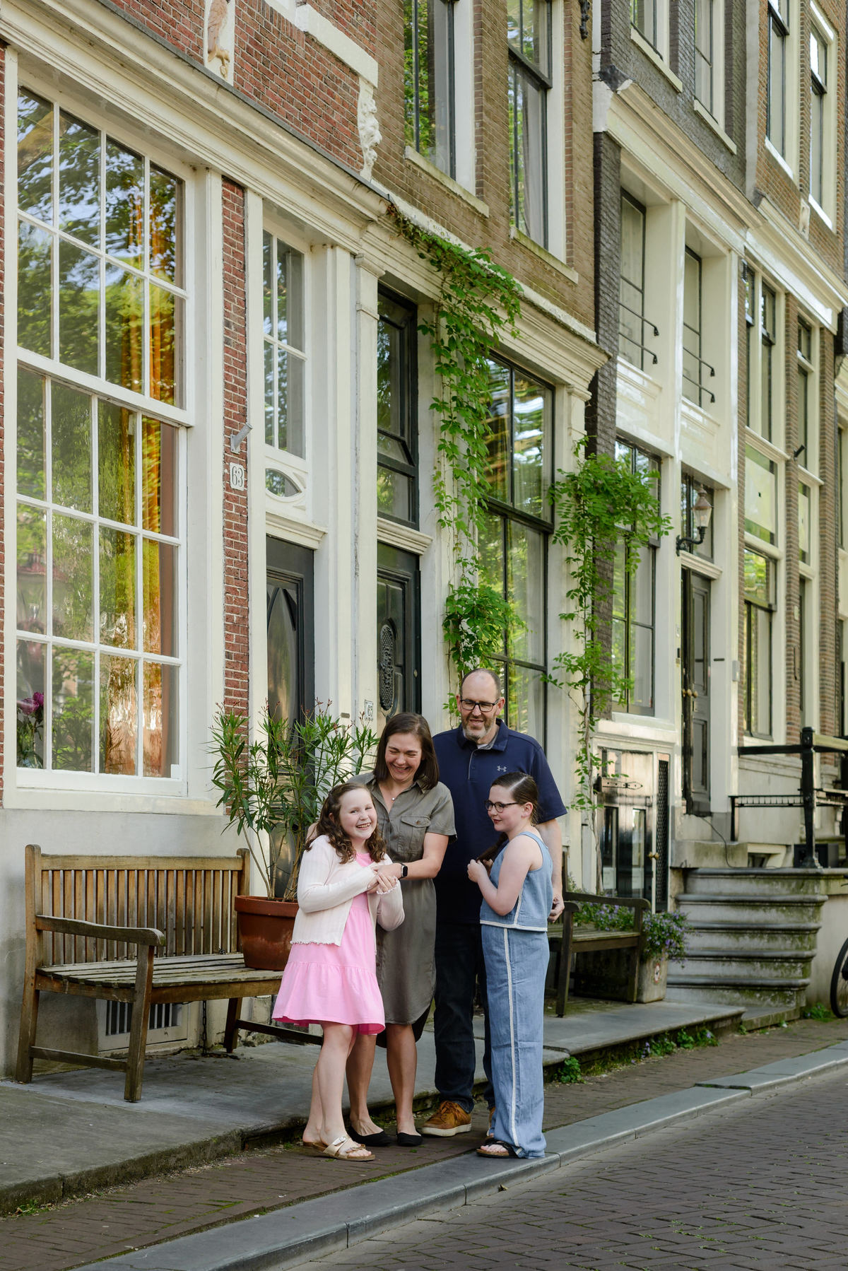 Parents sharing a candid moment with their daughters in Amsterdam.