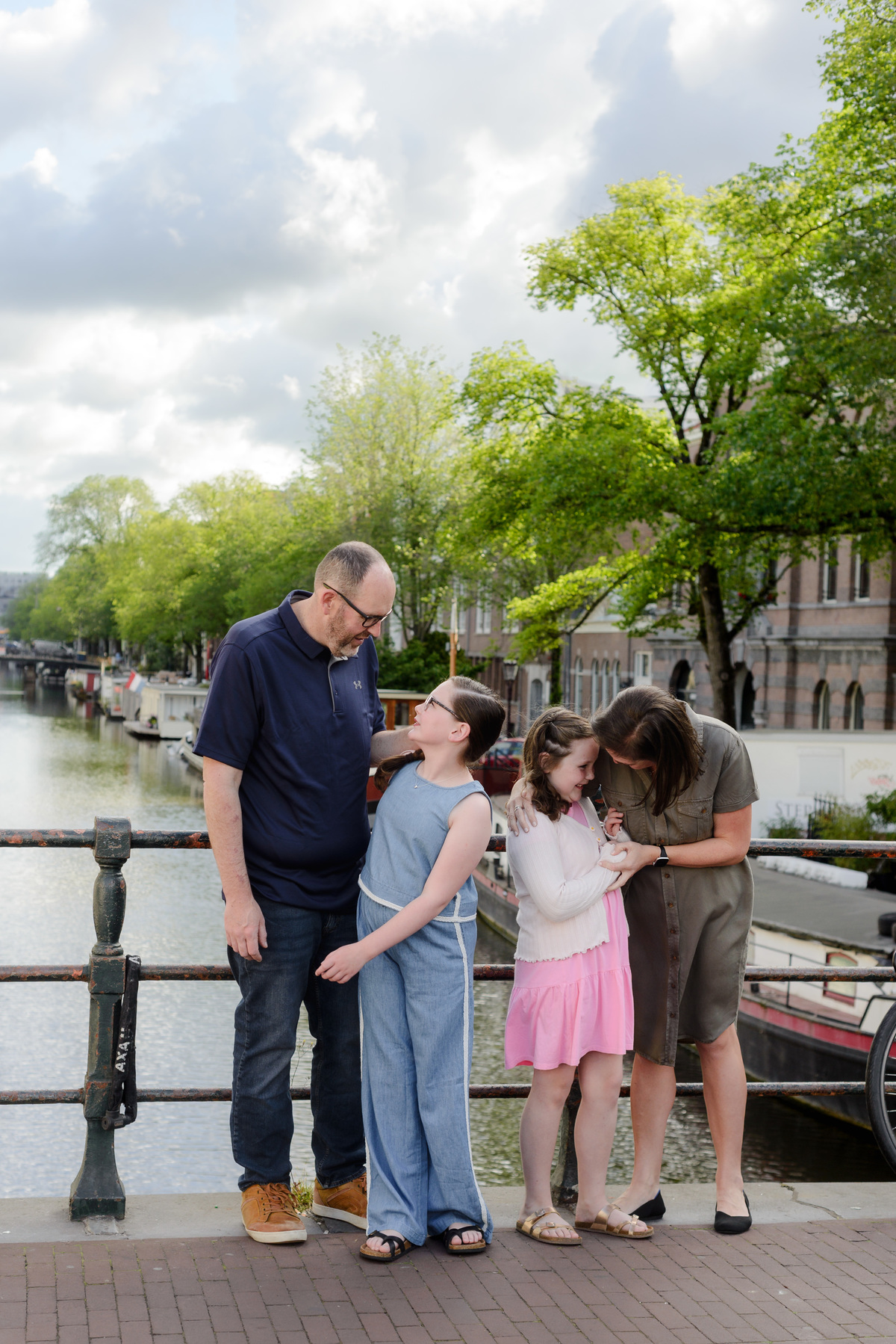 Parents sharing a candid moment with their daughters in Amsterdam.
