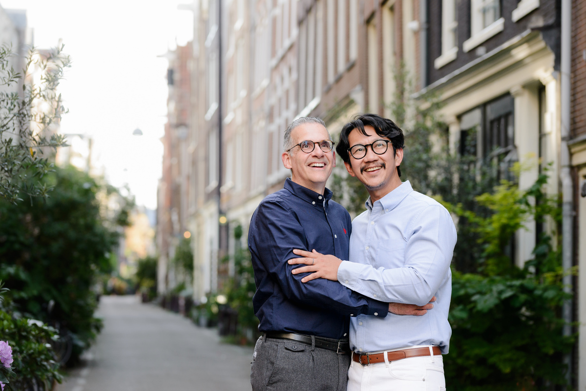 Natural portrait of a couple walking through Amsterdam's historic streets.