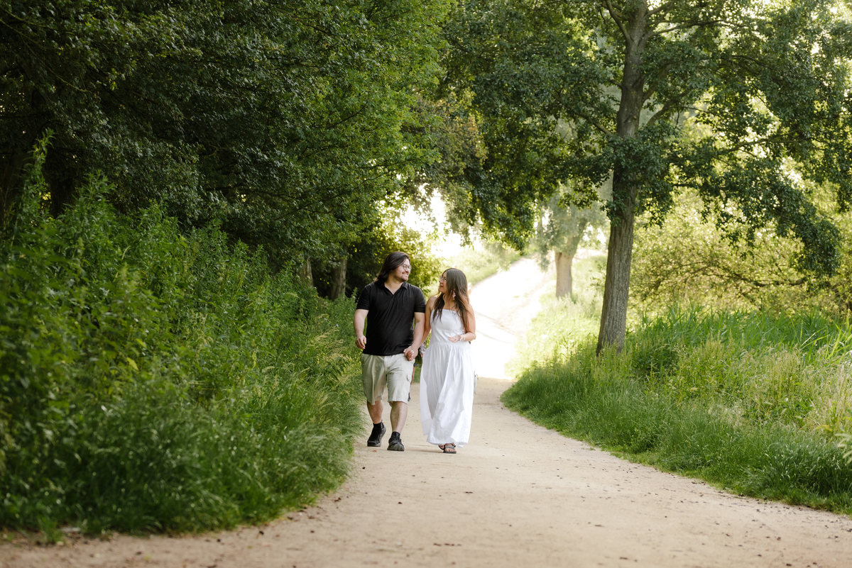 ngaged couple walking through Westerpark during a natural photo session.