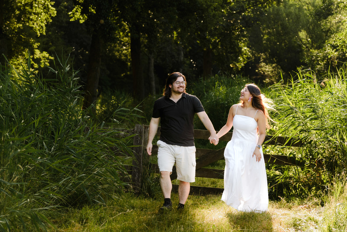 ngaged couple walking through Westerpark during a natural photo session.