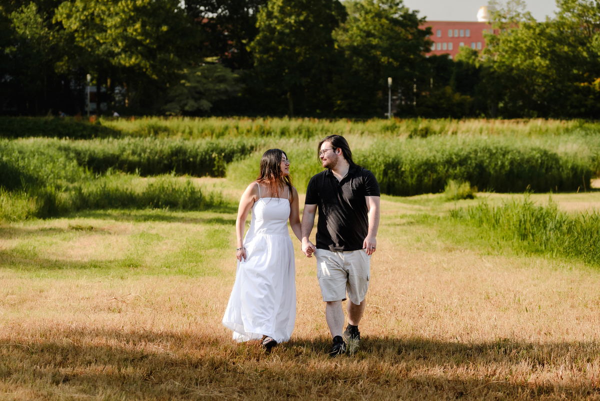 Couple holding hands beneath trees during an Amsterdam engagement session.