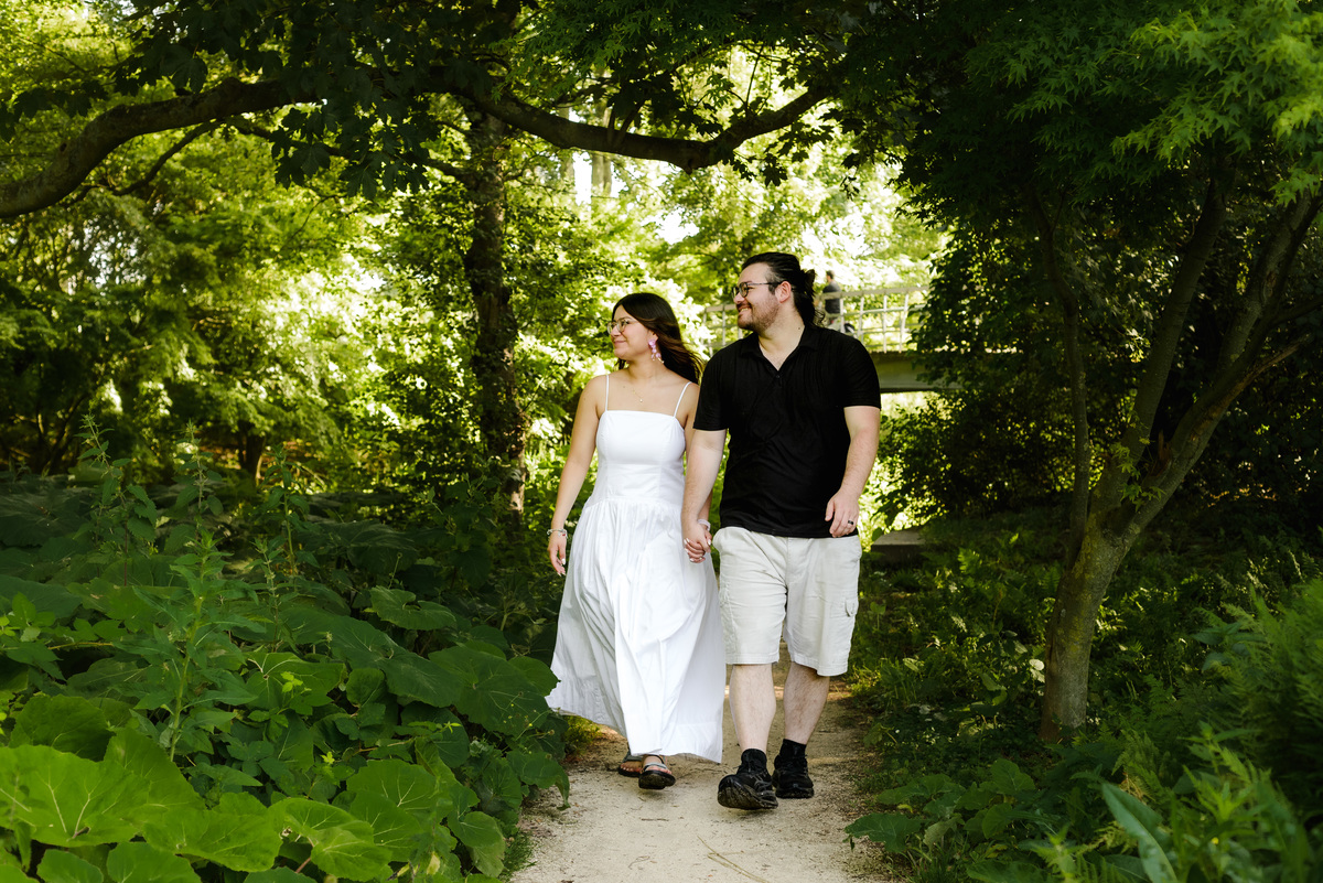 ngaged couple walking through Westerpark during a natural photo session.