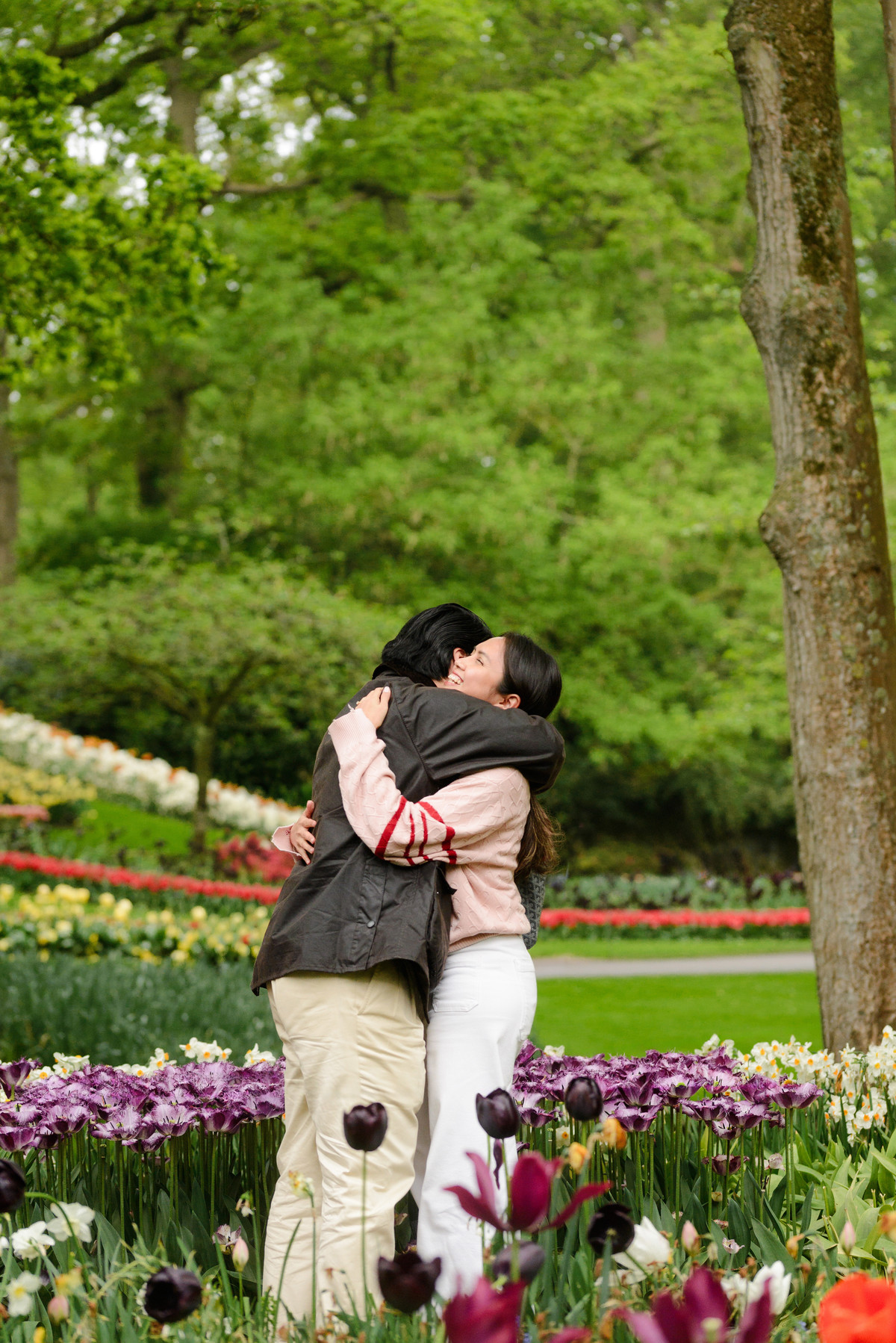 Newly engaged couple embracing among colourful flowers in the Netherlands.