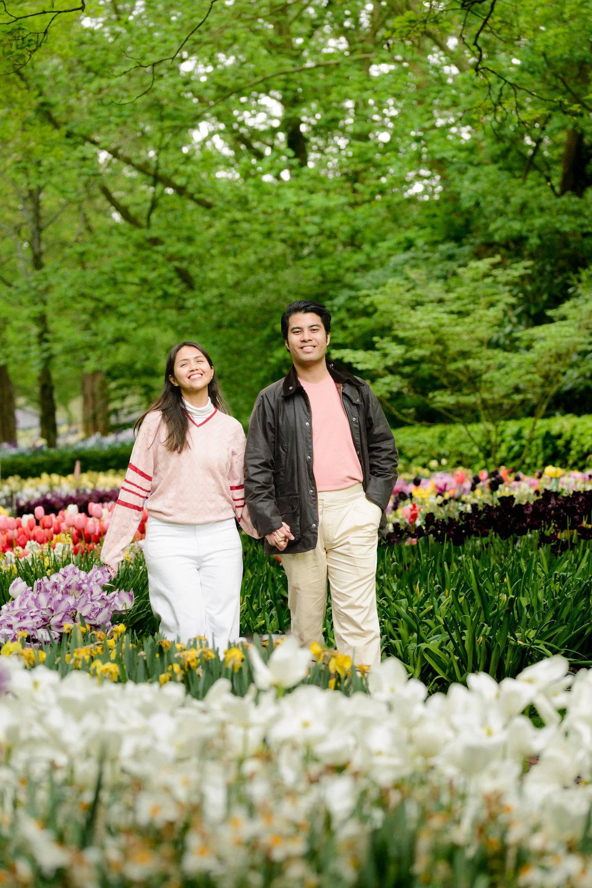 Couple walking together through Keukenhof after their proposal.