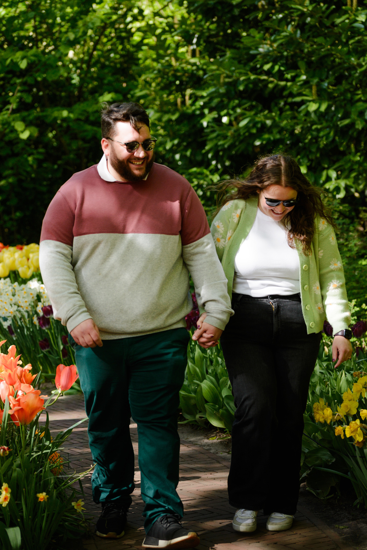 Newly engaged couple celebrating among spring flowers.